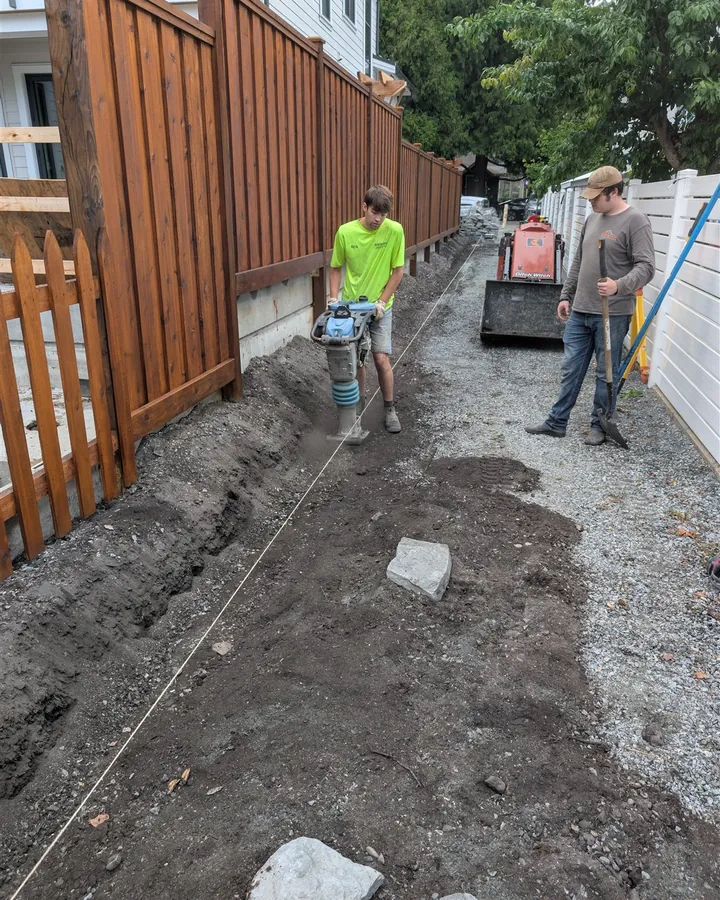 Adam and Ben Stafford compacting the base on a side-yard paver walkway