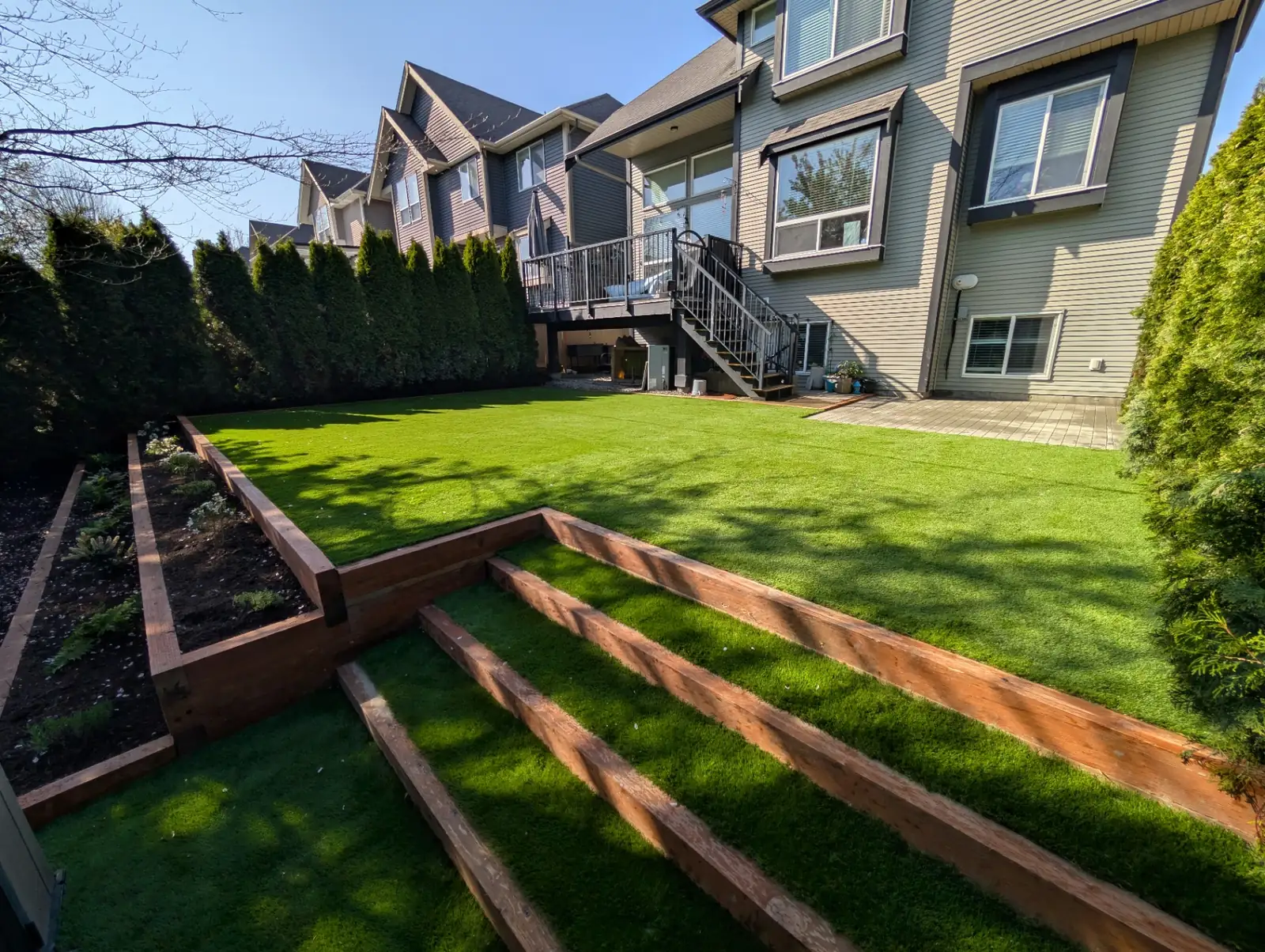After: finished artificial turf lawn with cedar retaining wall steps